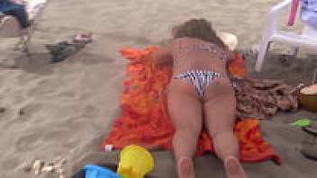 Stepmother masturbates and flaunts herself on the beach.